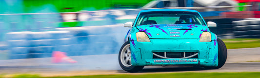 Turquoise 350Z drift car sliding through smoke for Driftaholic Racing sim drifting article