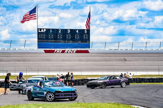 Drift cars at Rockingham Speedway with The Rock scoreboard in the background